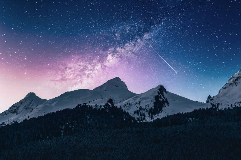 Sternenhimmel über verschneiten Berggipfeln