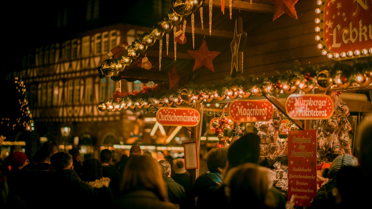 Besucher schlendern über einen weihnachtlich beleuchteten Markt