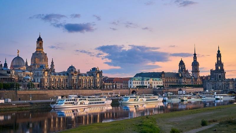 Dresdens Altstadt an der Elbe bei Sonnenuntergang mit Elbdampfern